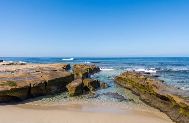 Horseshoe surf break in La Jolla, San Diego — whitewater running between the rocks over the right-hand shelf.